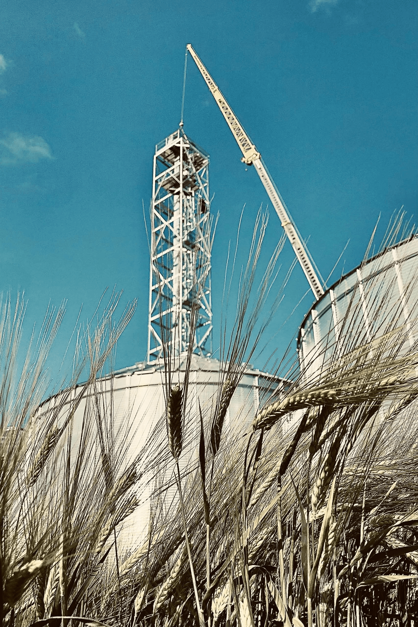 Crane setting the tower between two bins, barley in the foreground